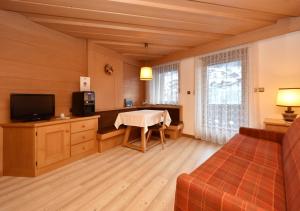 a large living room with a table and a television at Post Hotel Moena in Moena