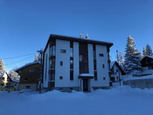 Un edificio con nieve delante en Apartmani MONT 1, en Jahorina