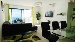 salon z czarną kanapą i szklanym stołem w obiekcie Apartamento Doreen w Caniço
