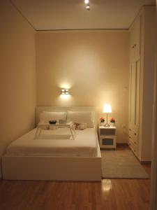 - une chambre avec un grand lit blanc et une lampe dans l'établissement Cosy Flat Posh Quartier Kolonaki, à Athènes