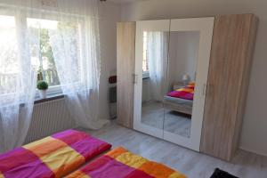 a bedroom with a mirror and a bed and a window at Appartmenthaus Kehrwieder in Sankt Peter-Ording
