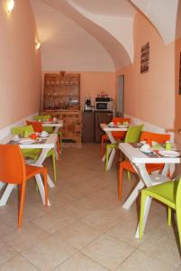 a restaurant with tables and chairs and a kitchen at La Cascina in Agliè