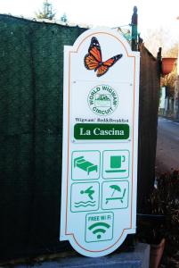 Una señal para un zoológico con una mariposa. en La Cascina, en Agliè