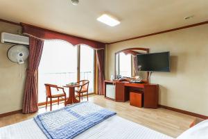 Sun Motel في جانجنيونج: غرفه فندقيه سرير وتلفزيون