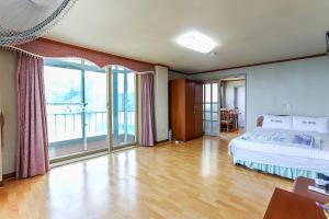 ein großes Schlafzimmer mit einem Bett und einem großen Fenster in der Unterkunft Sun Motel in Gangneung