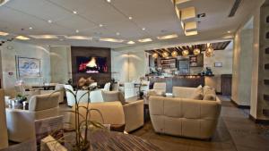 un vestíbulo con una sala de espera con sillas y mesas blancas en Al Rawasi Hotel Suites, en Yeda