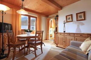 comedor con mesa y sofá en Landhaus Bachler en Brixen im Thale