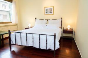 アテネにあるStephany Apartmentのベッドルーム1室(白いシーツ付きのベッド1台、窓付)