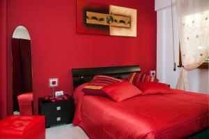 1 dormitorio rojo con 1 cama y pared roja en La Casetta del Vaticano, en Roma