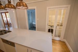 a kitchen with a white counter top in a room at Beautiful Queenslander in Townsville +18 photos