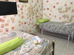 Cette chambre comprend 2 lits et une télévision à écran plat. dans l'établissement Homestay Pagar Buruk Ipoh, à Ipoh