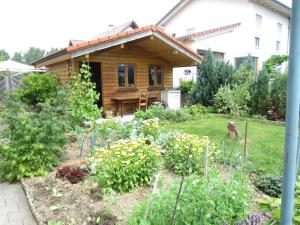 een tuin voor een houten huis bij Christine Oparaugo - Privatzimmer mit Bad in Leutkirch im Allgäu