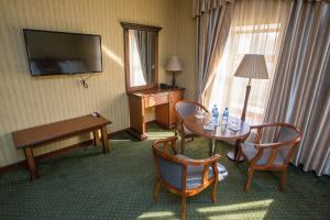 a hotel room with a table and chairs and a television at Karvon-Saroy Hotel in Andijan