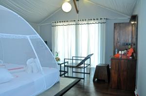 a bedroom with a large white bed and a table at Kottawatta Village in Udawalawe