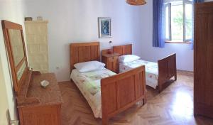 sypialnia z 2 łóżkami pojedynczymi i stołem w obiekcie Apartmani Tomica w mieście Jesenice