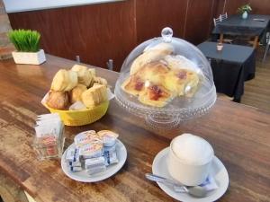 a table with a bowl of bread and a bowl of muffins at Gran Hotel Colón in Villa María