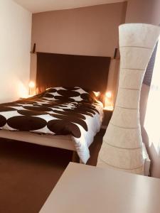 ヴィルヌーヴ・ダスクにあるChambre des Amisのベッドルーム(白黒のベッド、ランプ付)
