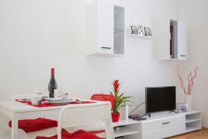a white dining room with a table and a tv at Stylish apartment a few steps from metro in Prague