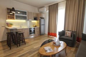 a kitchen and a living room with a table and chairs at Skinari Apartments in Monolia