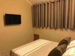 Uma TV ou centro de entretenimento em Amoreiras Hotel Pousada