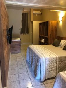 Uma TV ou centro de entretenimento em Amoreiras Hotel Pousada