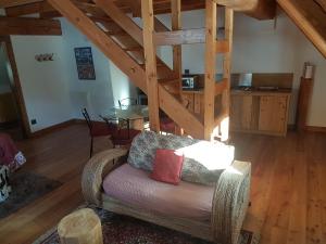 a living room with a chair and a table at La Lince Lodge in Camporosso in Valcanale