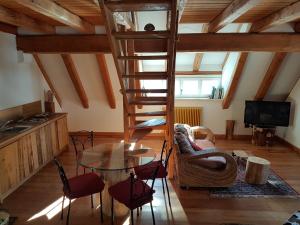 - un salon avec un escalier en colimaçon, une table et des chaises dans l'établissement La Lince Lodge, à Camporosso in Valcanale