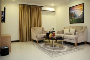 sala de estar con 2 sillas, sofá y mesa en Almuhaidb Residence Al Jubail, en Al Jubail