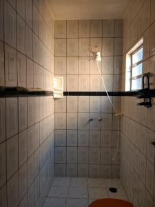 a bathroom with a shower with a light on the wall at Apartamento Águia Azul 10 Andar superior in Ilha Comprida