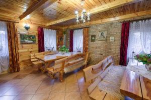 ein Esszimmer mit einem Tisch und Bänken in einer Hütte in der Unterkunft Aleksandrówka - Domek Aleksander in Trześcianka