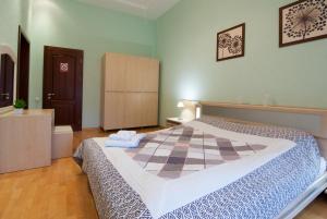 キーウにあるHome-Hotel Apartments-Mykhailivskaのチェッカーボード模様の大型ベッド1台が備わるベッドルーム1室