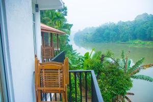 a balcony with chairs and a view of a river at Chaminrich Homestay in Kandy