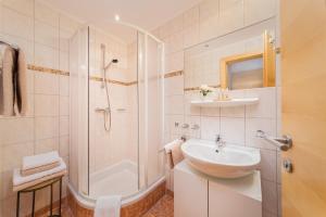 un bagno bianco con lavandino e doccia di Rainer's Appartements a Längenfeld