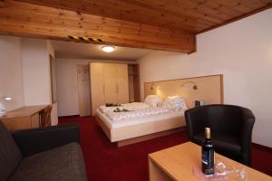 a bedroom with a bed and a bottle of wine on a table at Gästeheim Anni Winkler in Nauders