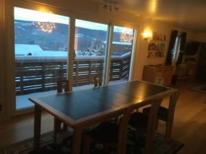 a table and chairs in a room with a large window at Bed and Breakfast Hadeland in Harestua