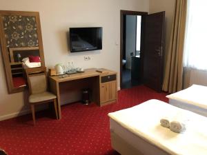 a hotel room with a desk and a television at Villa Zagórze in Rumia +21 photos