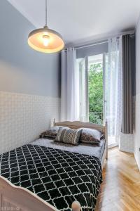 ワルシャワにあるClickTheFlat Wspólna Central Apart Roomsのベッドルーム1室(ベッド1台、大きな窓付)