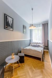 ワルシャワにあるClickTheFlat Wspólna Central Apart Roomsのベッドルーム(ベッド1台、テーブル付)