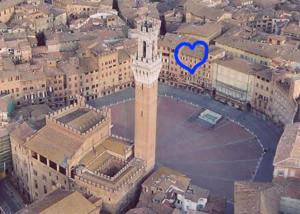 une grande tour d'horloge avec un cœur bleu dans l'établissement Palazzo Lenzi, à Sienne