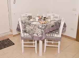 - une table à manger avec une nappe et des chaises dans l'établissement Casa Luna, à Naples