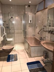 Ferienhaus Löhr mit Treppenlift في كوبلنز: حمام مع دش وحوض استحمام ومغسلة