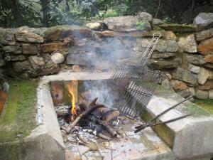 a fire in a stone wall with a grill at Casa Rural en la Montaña Mas de Tenesa in Benasal