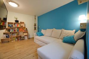 a living room with a white couch and a blue wall at Sea house in Izola