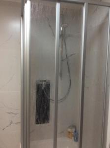 La salle de bains est pourvue d'une douche avec une porte en verre. dans l'établissement Sanhe, à Rollingen