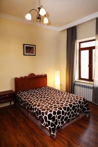 a bedroom with a bed with a black and white comforter at Apartments Aigedzor in Yerevan