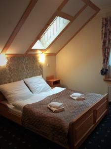 a bedroom with a bed with two towels on it at Oro Cavallo in Karpacz