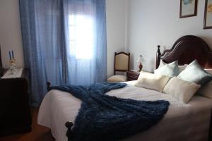 um quarto com uma cama com um cobertor azul em Casa da tia Bina em Monsaraz