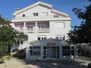 un grand bâtiment blanc avec un décor rose dans l'établissement Apartments Nina, à Zadar