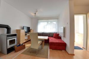 レンヴェークにあるKatschberg Appartementsのリビングルーム(赤いソファ、テーブル付)