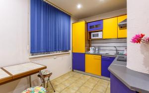 モスクワにあるFortEstate Apartment Vorontsovskiy Parkのキッチン(黄色と青色のキャビネット、テーブル付)